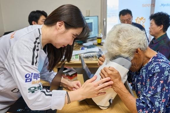 경기도 안산시 대부도 주민이 AI 실명질환 진단 솔루션 '위스키'와 안저카메라 '옵티나 제네시스'를 활용해 안저 상태를 확인하고 있다./대웅제약 제공